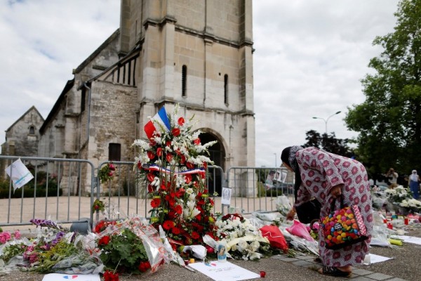 Una musulmana observa en silencio las flores en la Iglesia de Saint Etienne, Francia/ Foto: AFP