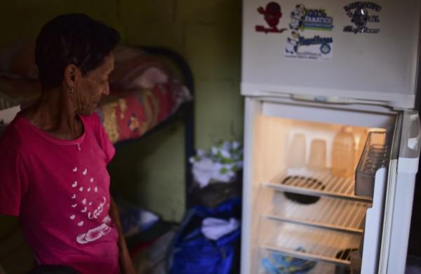 Mayra de Ramos muestra su nevera vacía en la cocina de su casa en un barrio pobre de Gramoven, Caracas, 2 de junio de 2016/ Foto: AFP