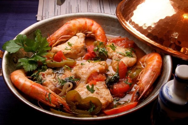 Un contundente y sabroso plato hecho a base de cabezas de camarones, pescados, langosta y otros mariscos, acompañados de tomate y azafrán.