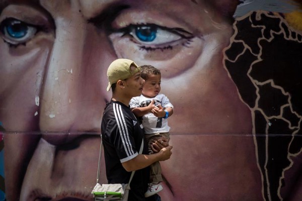 Fotografía del 26 de febrero del 2017 de un hombre con un niño en brazos en Caracas/ Foto: EFE