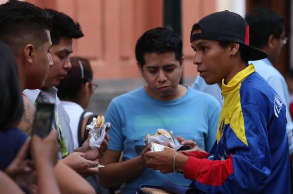 Fotografía del 11 de abril de 2017 de un inmigrante venezolano vendiendo arepas por el jirón de la unión del centro histórico de Lima (Perú)/ Foto: EFE