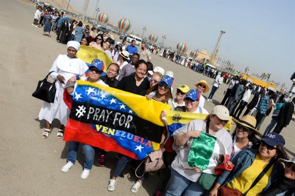 Fieles esperan la llegada del Papa a la misa y piden "Rezar por Venezuela" con una bandera del país suramericano/ Foto: EFE