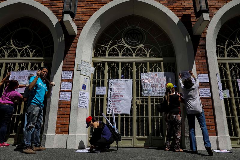Manifestantes colocan pancartas en un centro de votación en Caracas/Foto: EFE