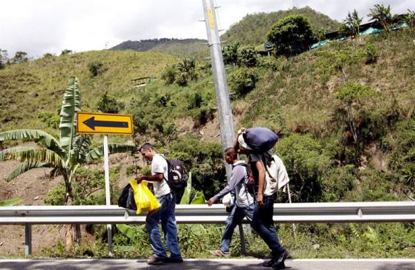 Fotografía fechada el 22 de Mayo de 2018 que muestra al venezolano Anthony Bogado (i), de 35 años, acompañado de un primo de 43 y un sobrino de 18, con quienes lleva dos días caminando por la vía Cúcuta - Pamplona en la población de Los Patios (Colombia)/ Foto: EFE