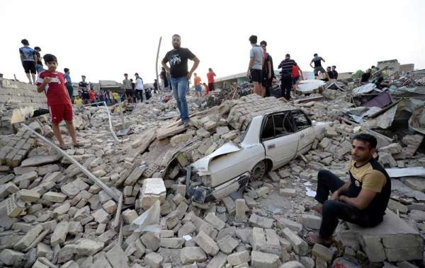 Varios iraquíes observan los daños causados tras una explosión en un depósito de armas en Ciudad Sadr, barrio de las afueras de Bagdad (Irak)/ Foto: EFE