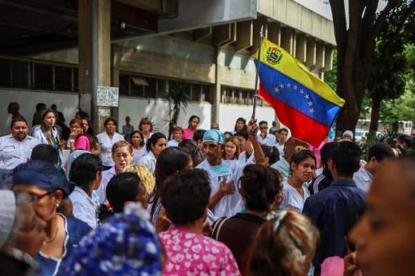 Trabajadores con la bandera de Venezuela se reunen para protestar