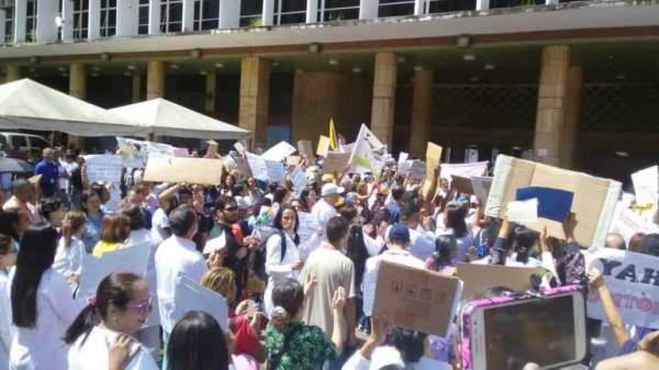 Grupo de parsonas con pancartas protesta frente a un edificio gubernamental