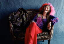Janis Joplin reclinada en un sofá durante el set de fotos para la portada del disco Pearl
